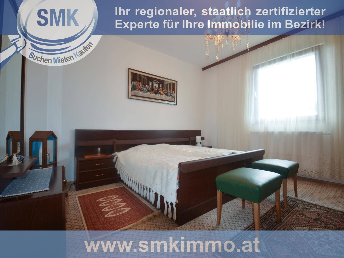 Schlafzimmer mit Doppelbett, Teppichboden und einem Fenster mit Vorhängen.