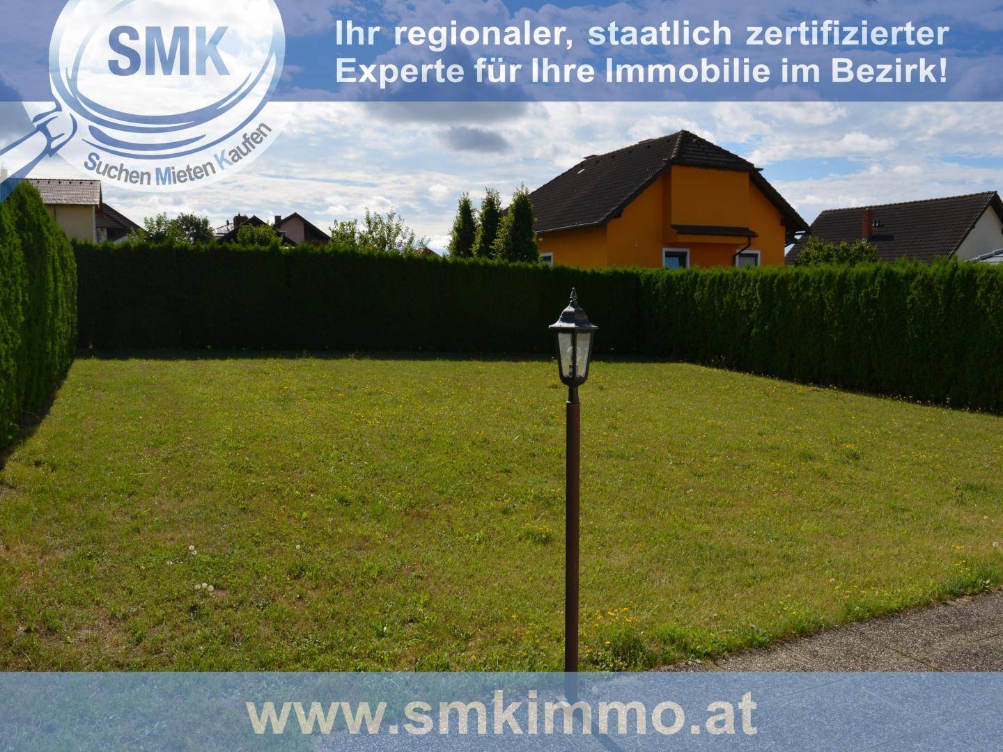 Gepflegte Rasenfläche mit einer hohen Hecke im Hintergrund und einer Gartenlaterne.