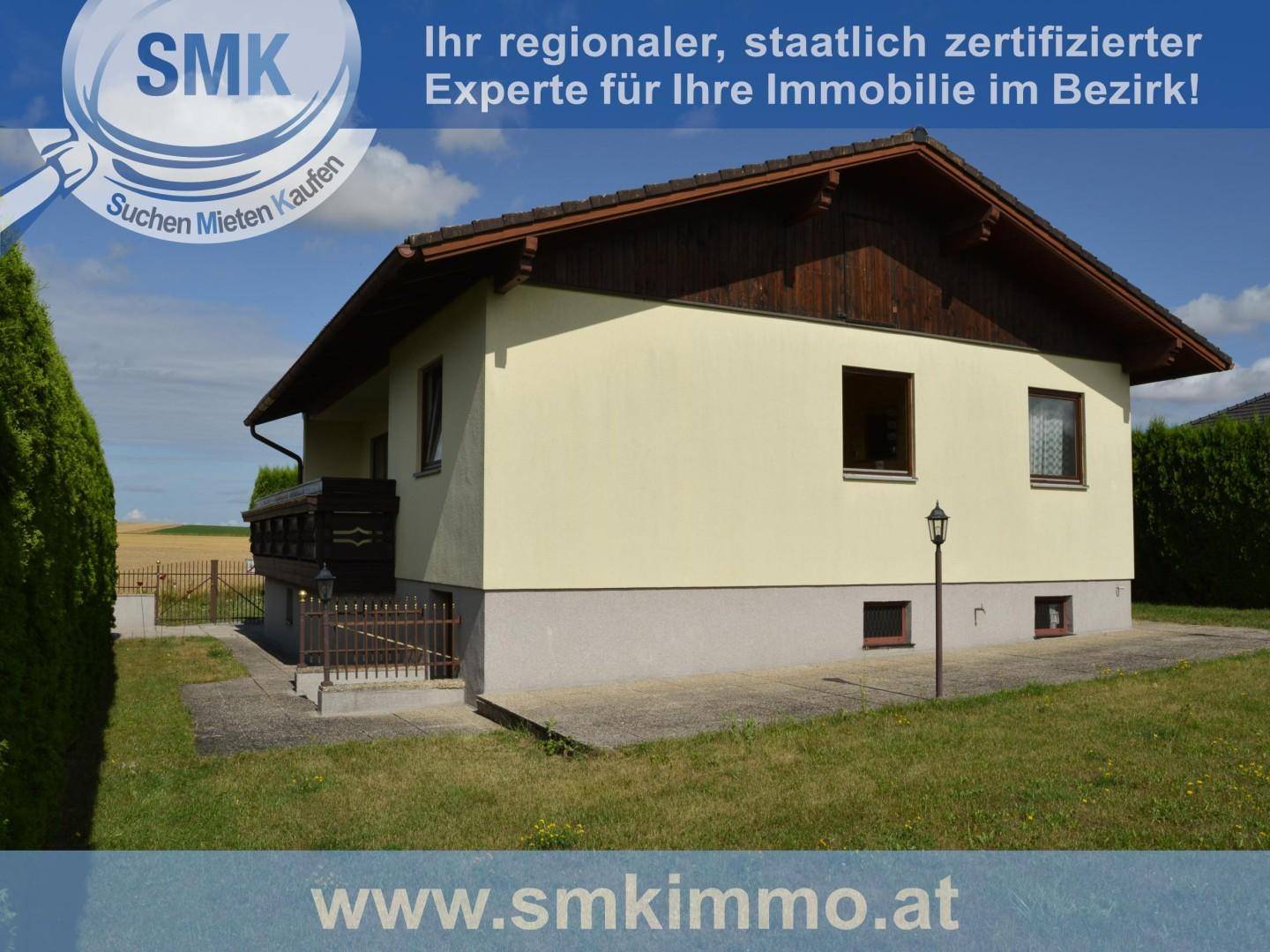 Seitenansicht eines Einfamilienhauses mit Satteldach und einer Rasenfläche.