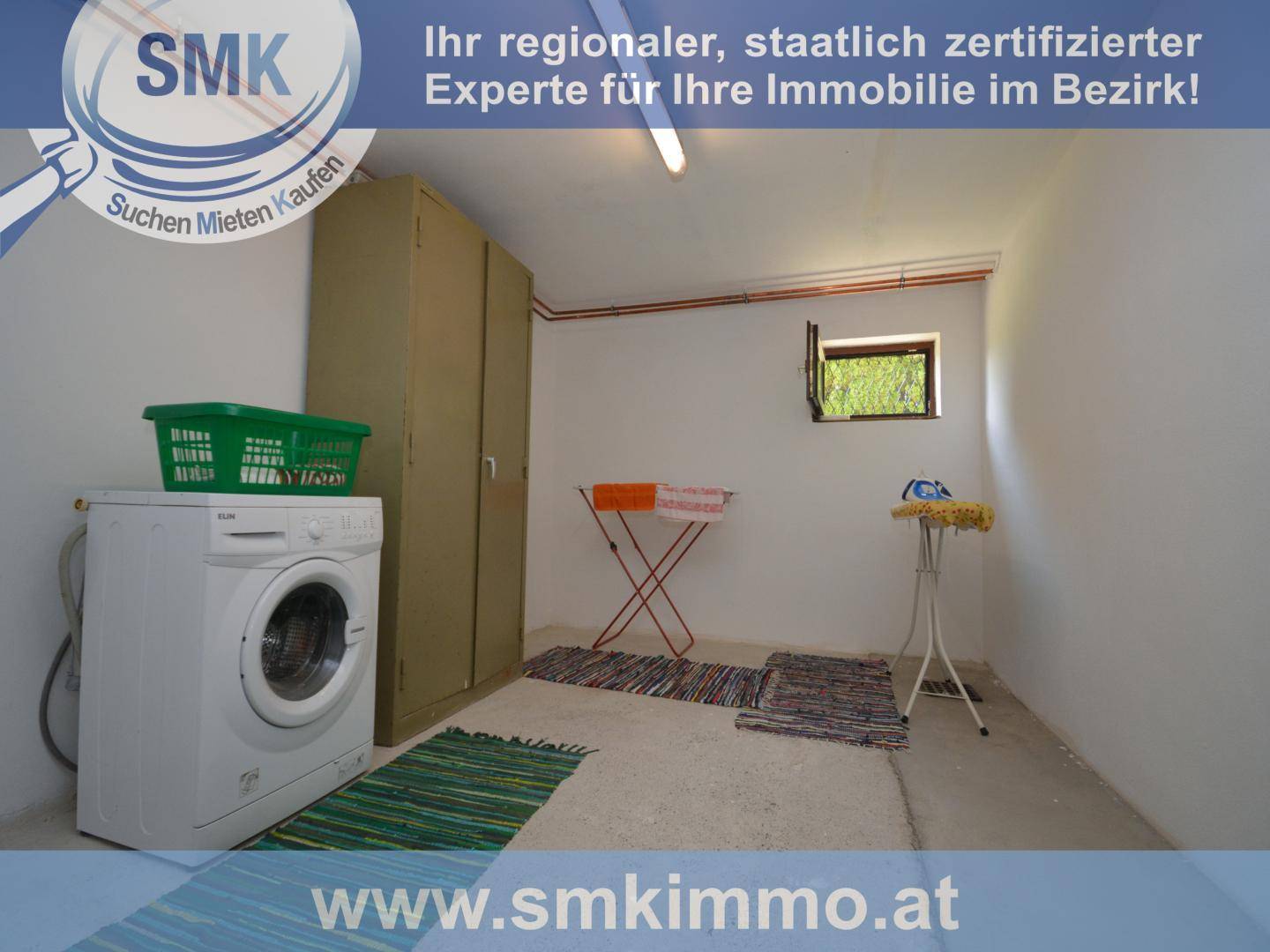 Hauswirtschaftsraum im Untergeschoss mit Waschmaschine, Schränken und Wäscheständern.