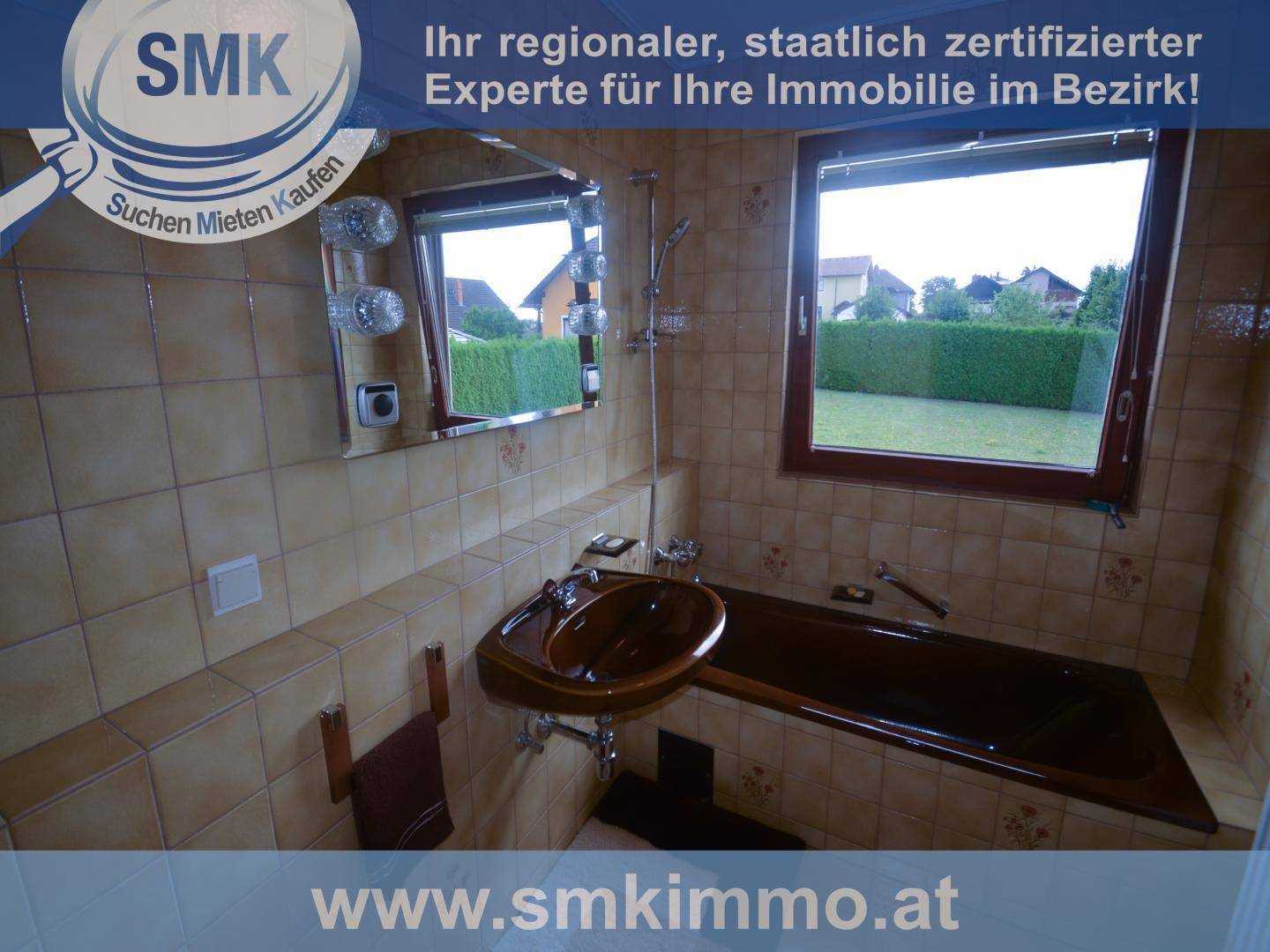 Badezimmer mit braunen Fliesen, Badewanne, Waschbecken und einem Fenster.