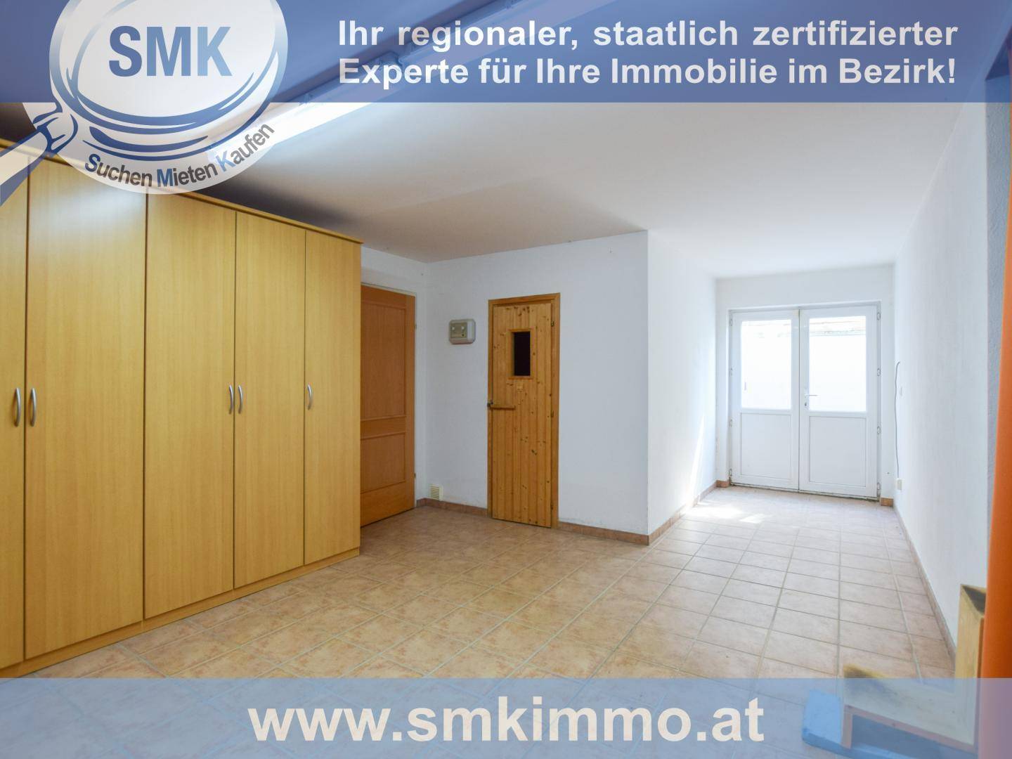 Helles Zimmer mit Fliesenboden, großem Kleiderschrank und Zugang zum Außenbereich.
