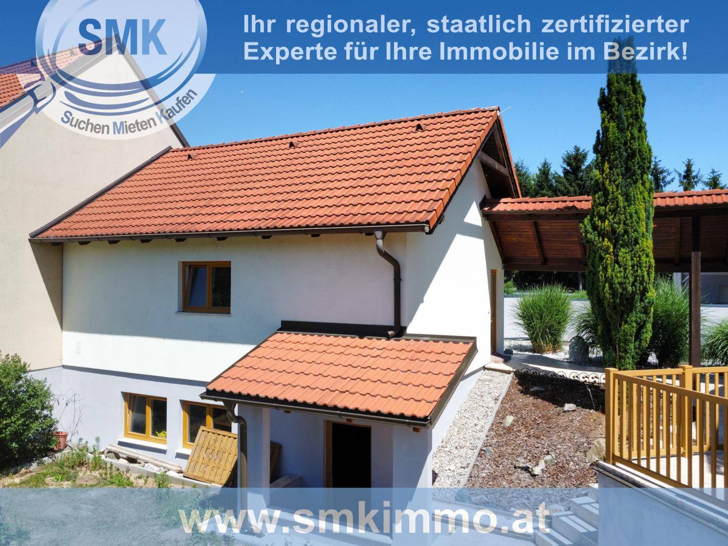 Seitenansicht des Hauses mit Kellerzugang, rotem Ziegeldach und gepflegter Umgebung.