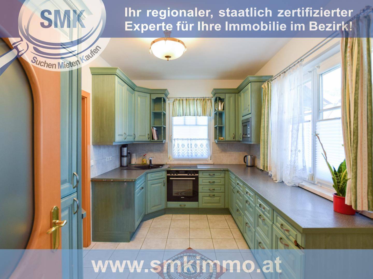 Traditionelle Küche mit mintgrünen Holzschränken, Fliesenboden und Fensterblick ins Grüne.