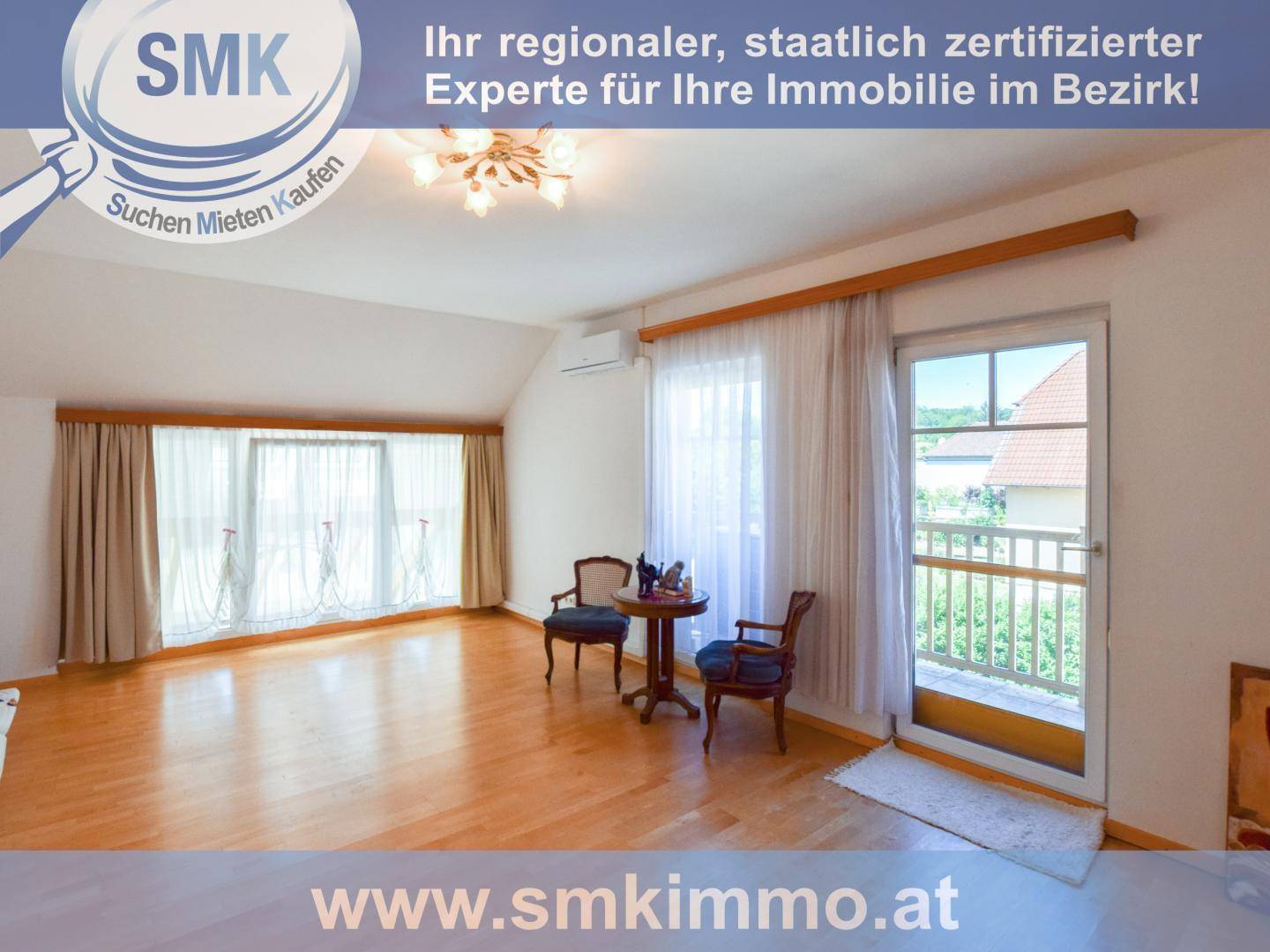 Helles Zimmer im Obergeschoss mit Holzboden, Balkonzugang und Blick ins Grüne.