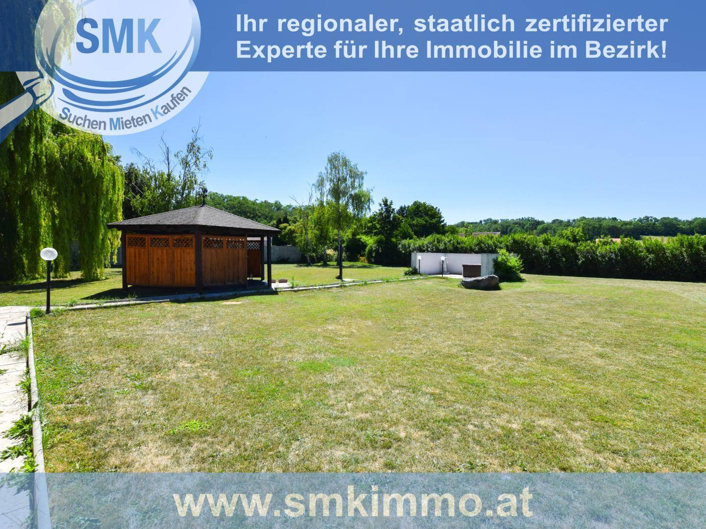 Weitläufiger Garten mit großer Rasenfläche, Gartenlaube und altem Baumbestand.