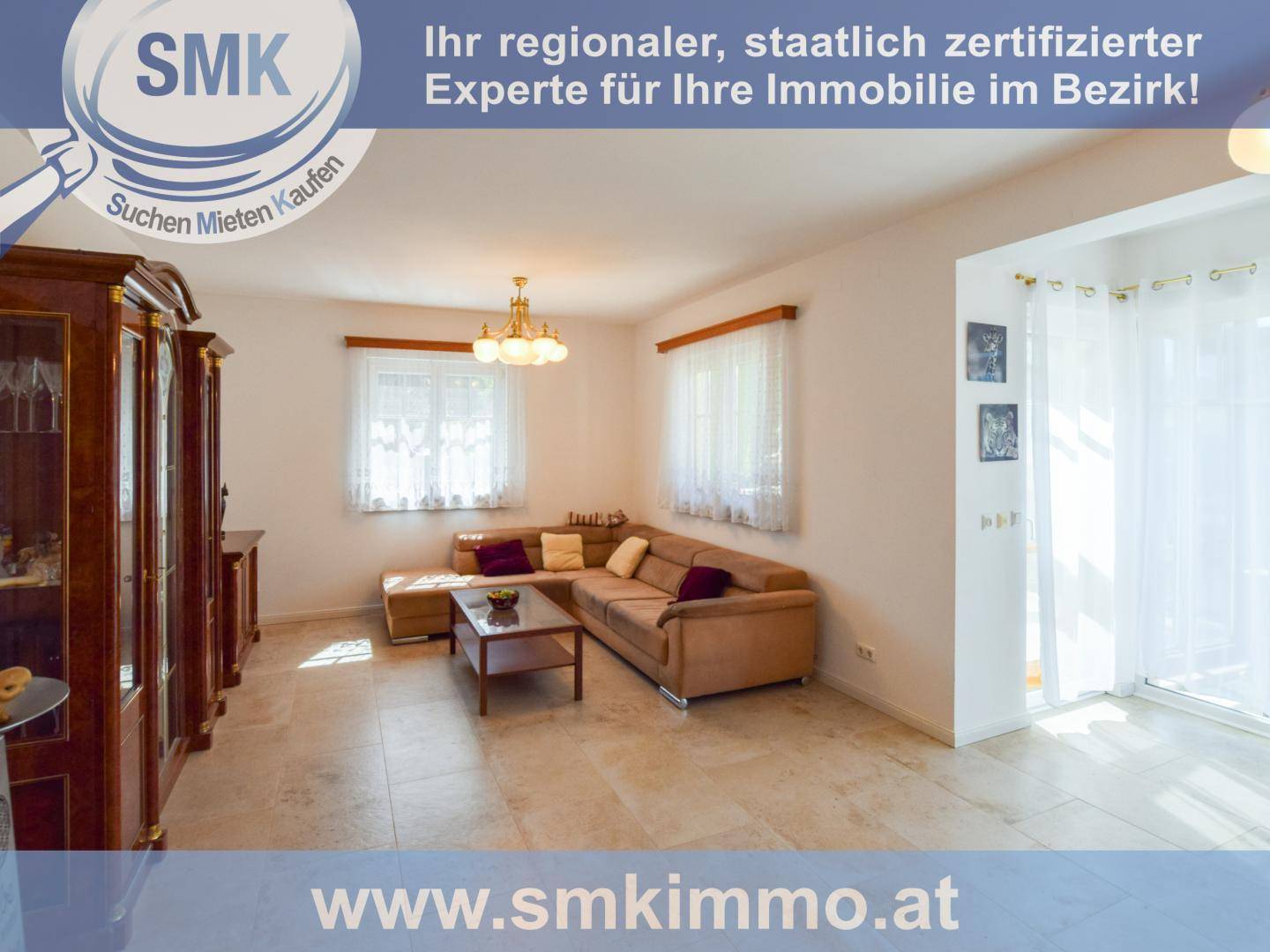 Geräumiges Wohnzimmer mit beigem Ecksofa, Holzmöbeln und Fliesenboden.