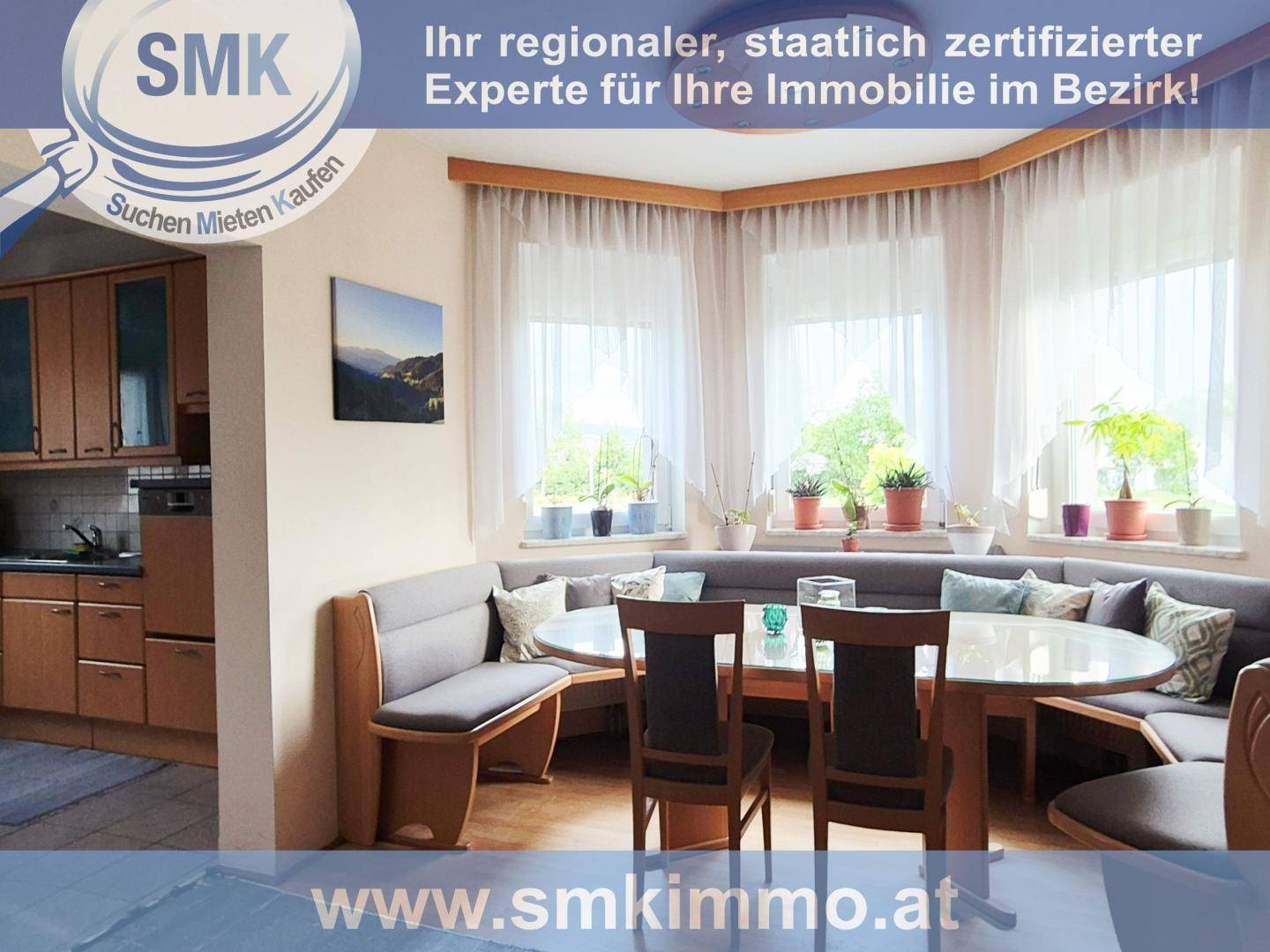 Heller Essbereich mit runder Eckbank, großem Tisch und Blick in die Küche.