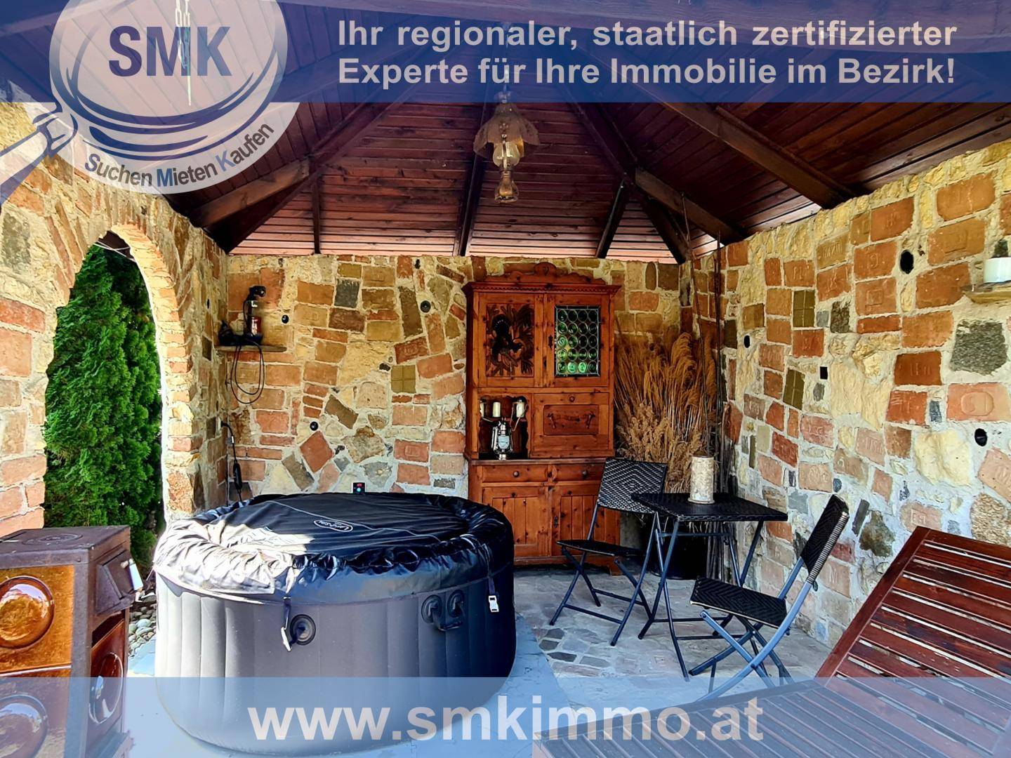 Überdachter Terrassenbereich mit Whirlpool, Steindekoration und Sitzgelegenheiten.