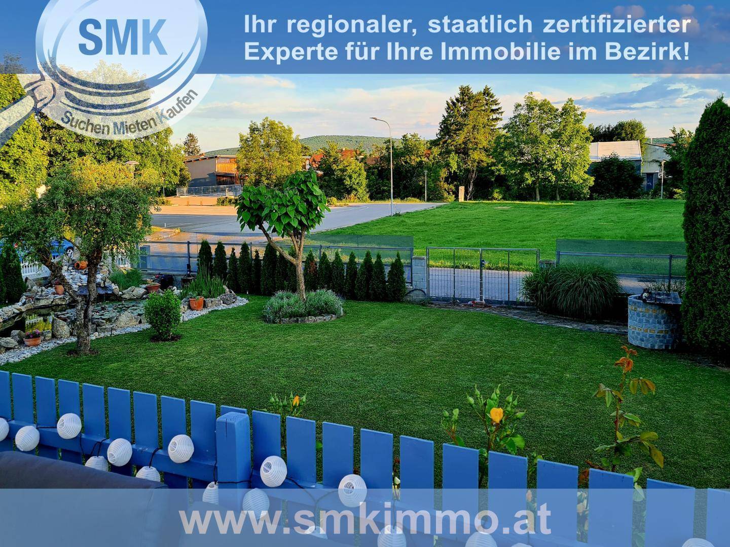 Gepflegter Garten mit Rasenfläche, Hecken und Blick auf die Umgebung.
