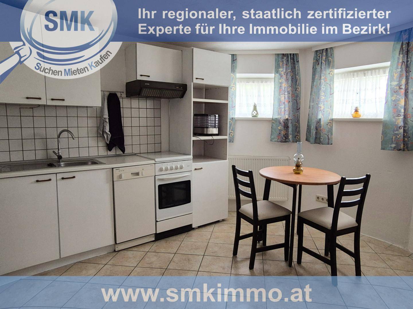 Kleine Küche mit weißen Schränken, Elektroherd und Essbereich für zwei Personen.