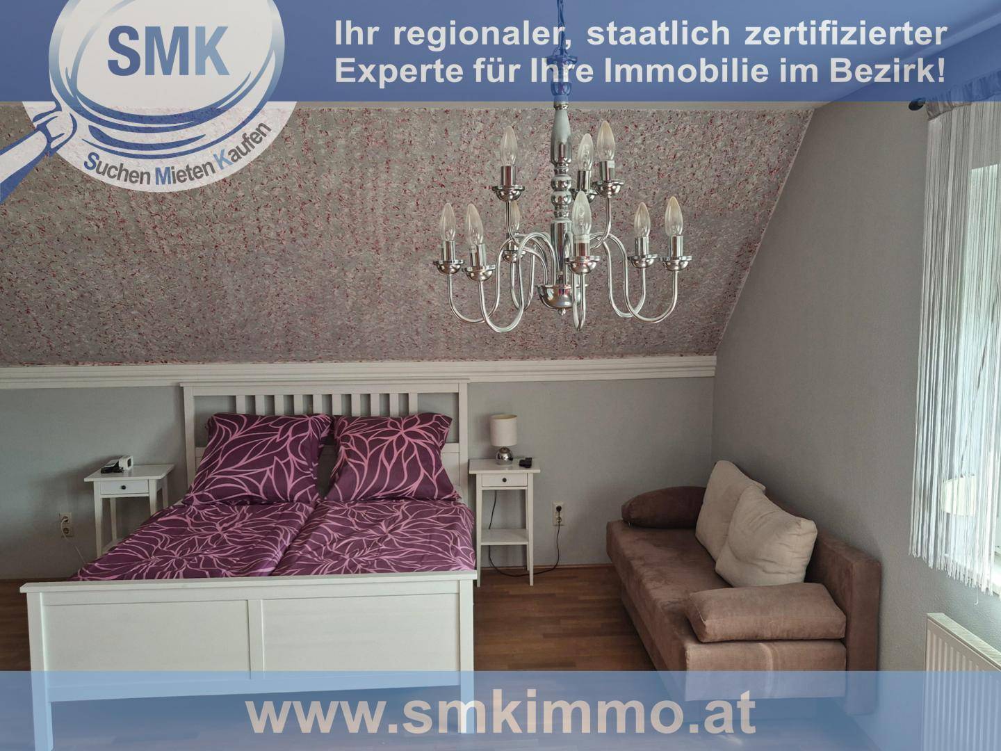 Schlafzimmer im Dachgeschoss mit Doppelbett, Nachttischen und Kronleuchter.