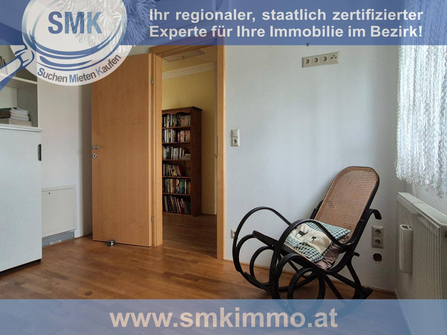 Heller Bereich mit Schaukelstuhl und Zugang zu einem weiteren Zimmer mit Bücherregal.