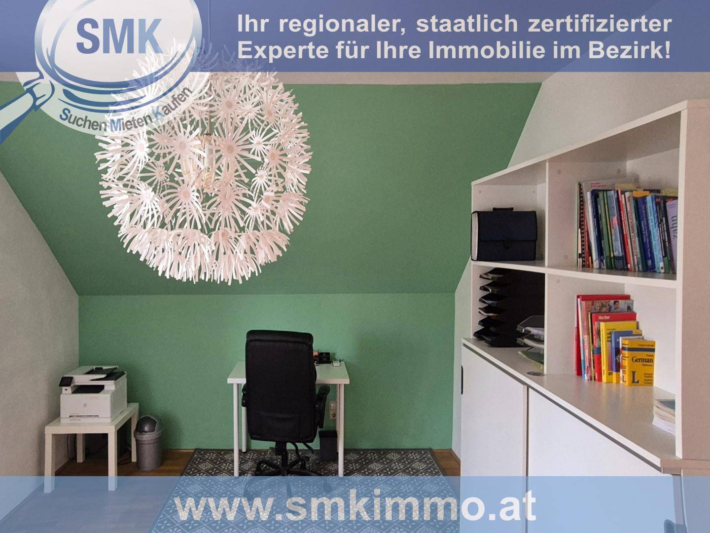 Helles Arbeitszimmer im Dachgeschoss mit Schreibtisch, Regal und grüner Wand.