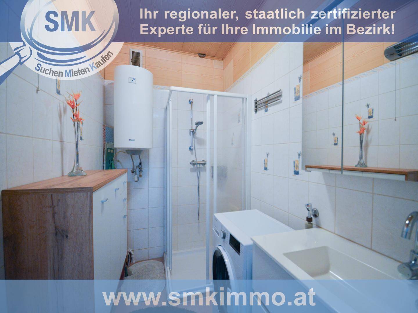 Funktionales Badezimmer mit Duschkabine, Waschbecken, Waschmaschine und Warmwasserboiler.
