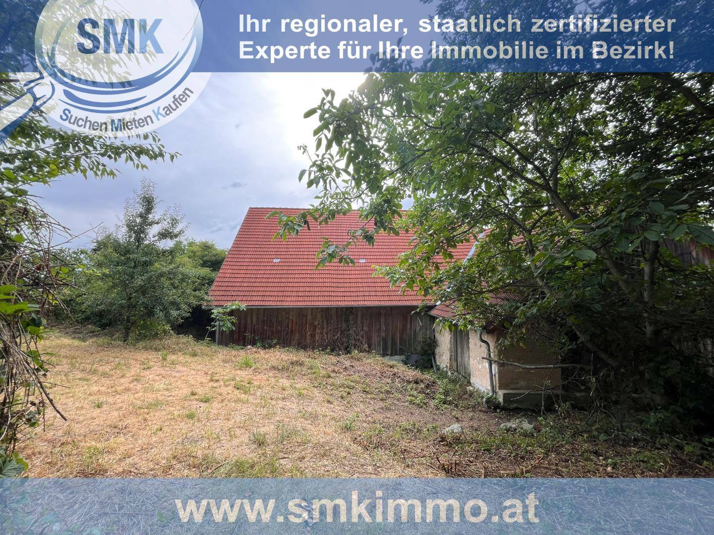 Rustikales Nebengebäude mit rotem Ziegeldach und verwildertem Grundstück im ländlichen Bereich.