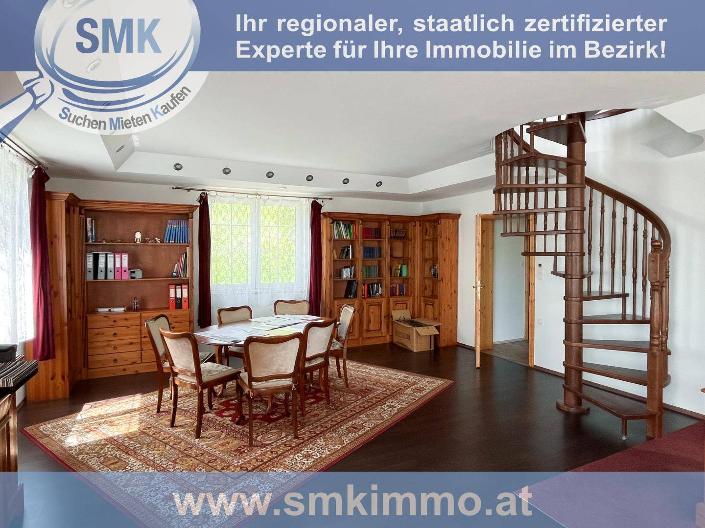 Traditioneller Essbereich mit großem Holztisch, Bücherregalen und einer Wendeltreppe.
