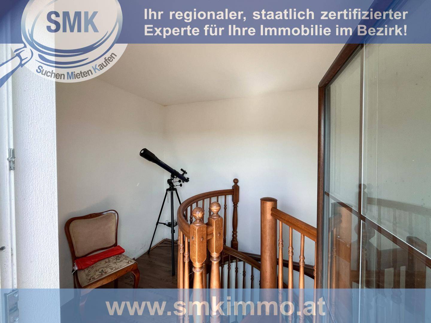 Heller Treppenabsatz mit Holzgeländer und einem Teleskop am Fenster.