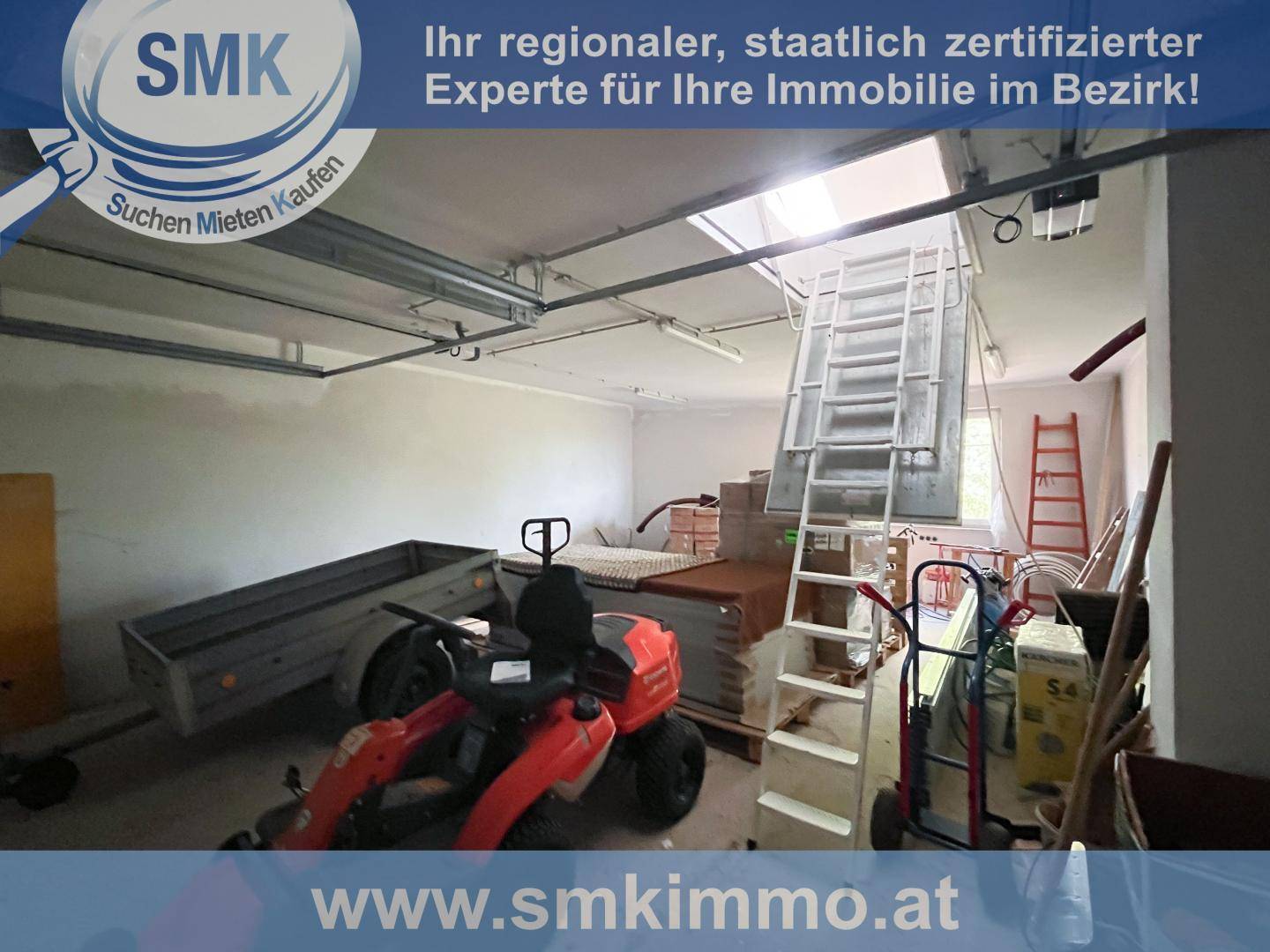 Geräumige Garage mit Leiter zum Dachboden und verschiedenen Geräten.