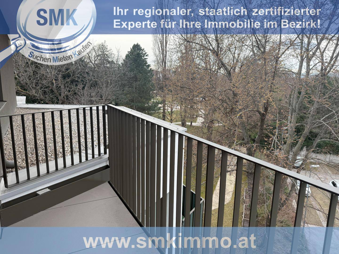 Balkon mit Metallgeländer bietet einen Blick auf die umliegenden Bäume und die Natur.