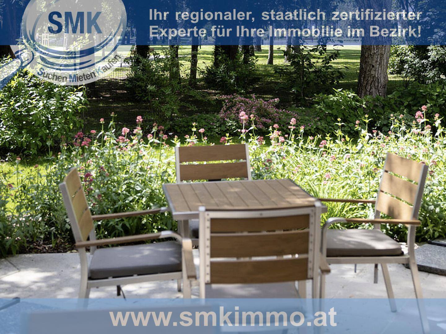 Gemütlicher Sitzbereich im Garten, umgeben von Blumen und Pflanzen, ideal zum Entspannen.