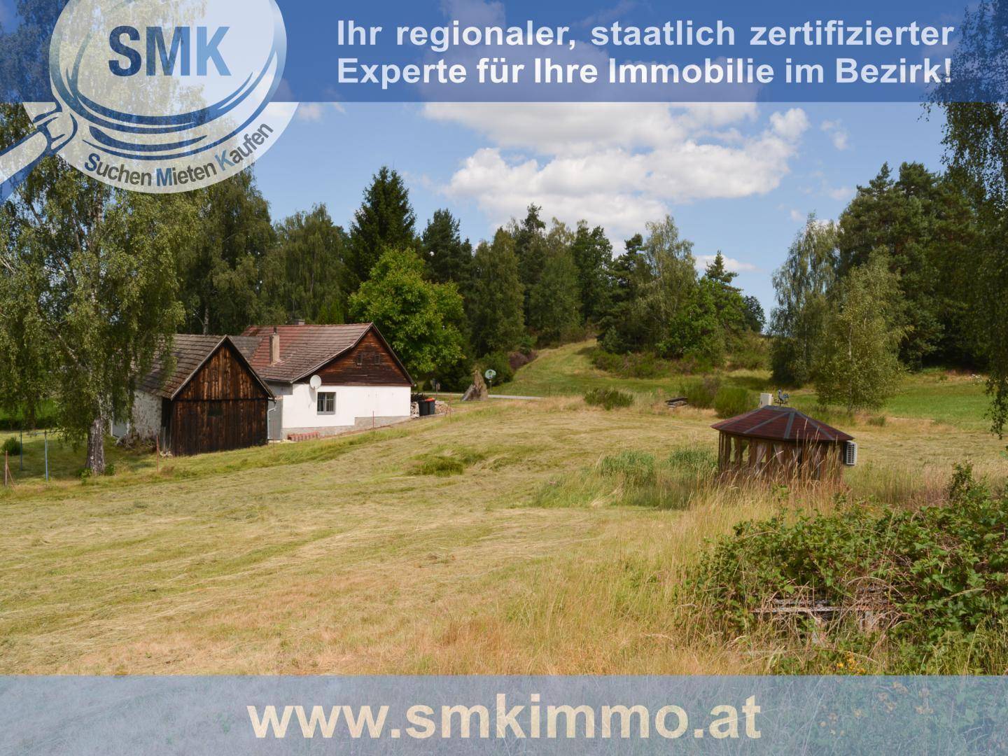 Ländliche Szene mit einem Feld, einem Holzpavillon und einem traditionellen Haus im Hintergrund.