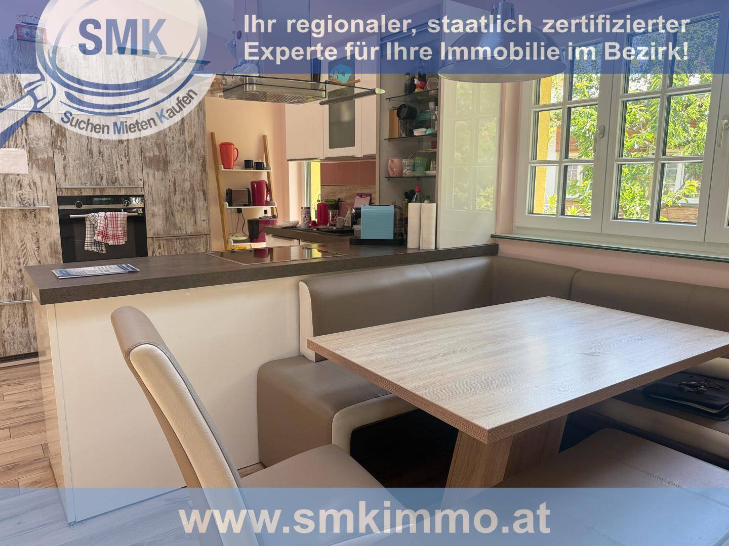 Moderne Küche mit integriertem Essbereich und Blick auf den Garten durch das Fenster.