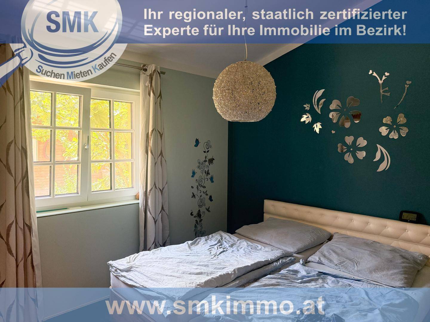 Schlafzimmer mit Doppelbett, einem Fenster und einer dekorativen Wand in dunklem Türkis.