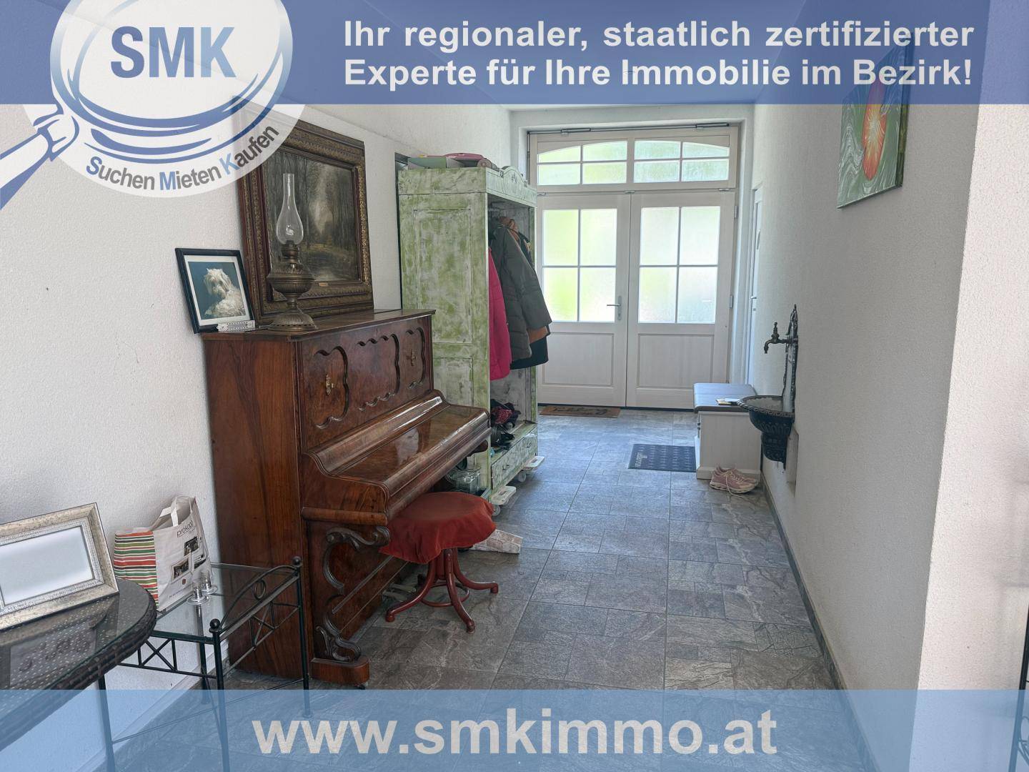 Geräumiger Flur mit einem antiken Klavier, Garderobe und Zugang zum Eingangsbereich.