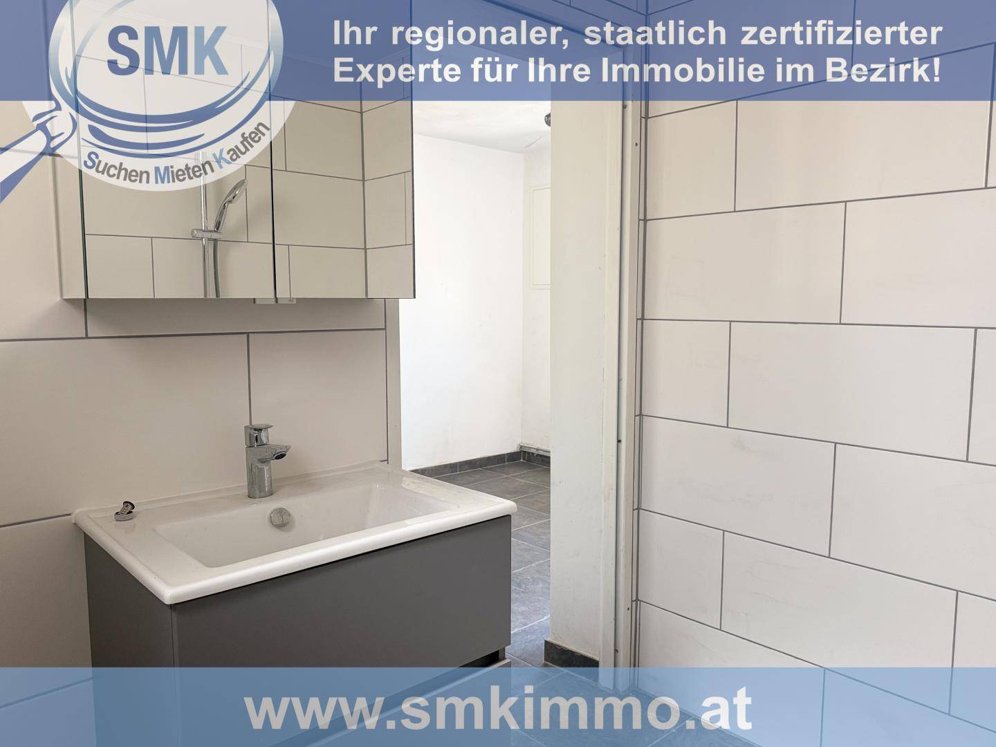Modernes Badezimmer mit Waschbecken, Spiegelschrank und weißen Fliesen, sauber und funktional.