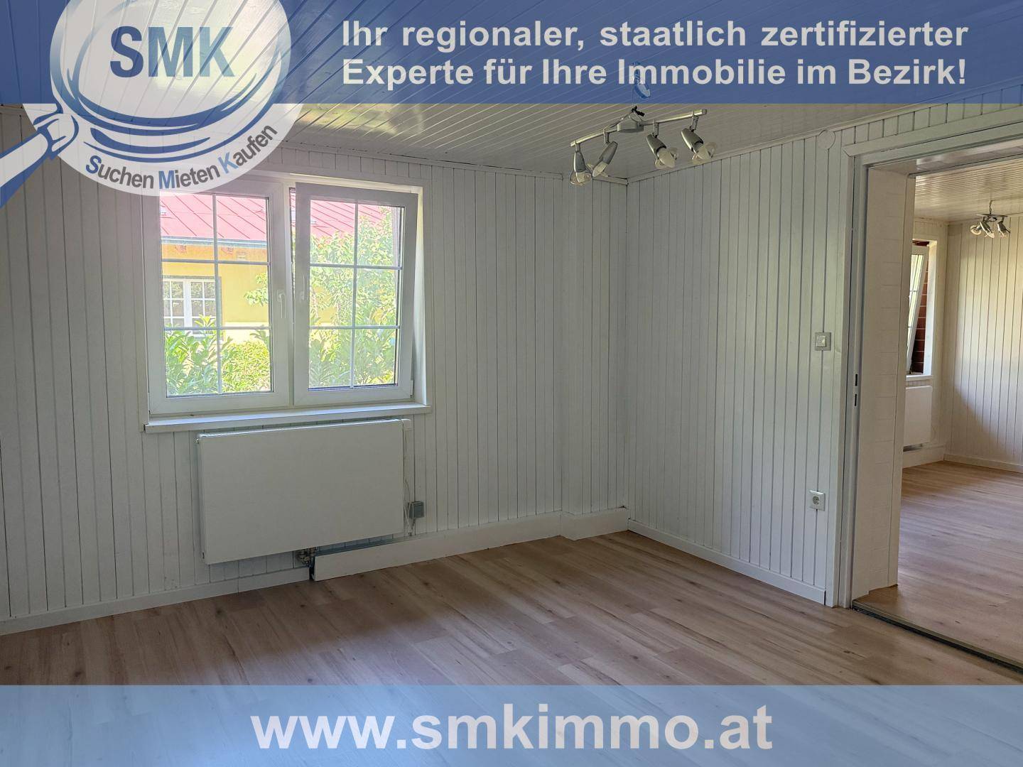 Heller Raum mit Holzverkleidung, einem Fenster und einem Heizkörper, bereit zur individuellen Gestaltung.