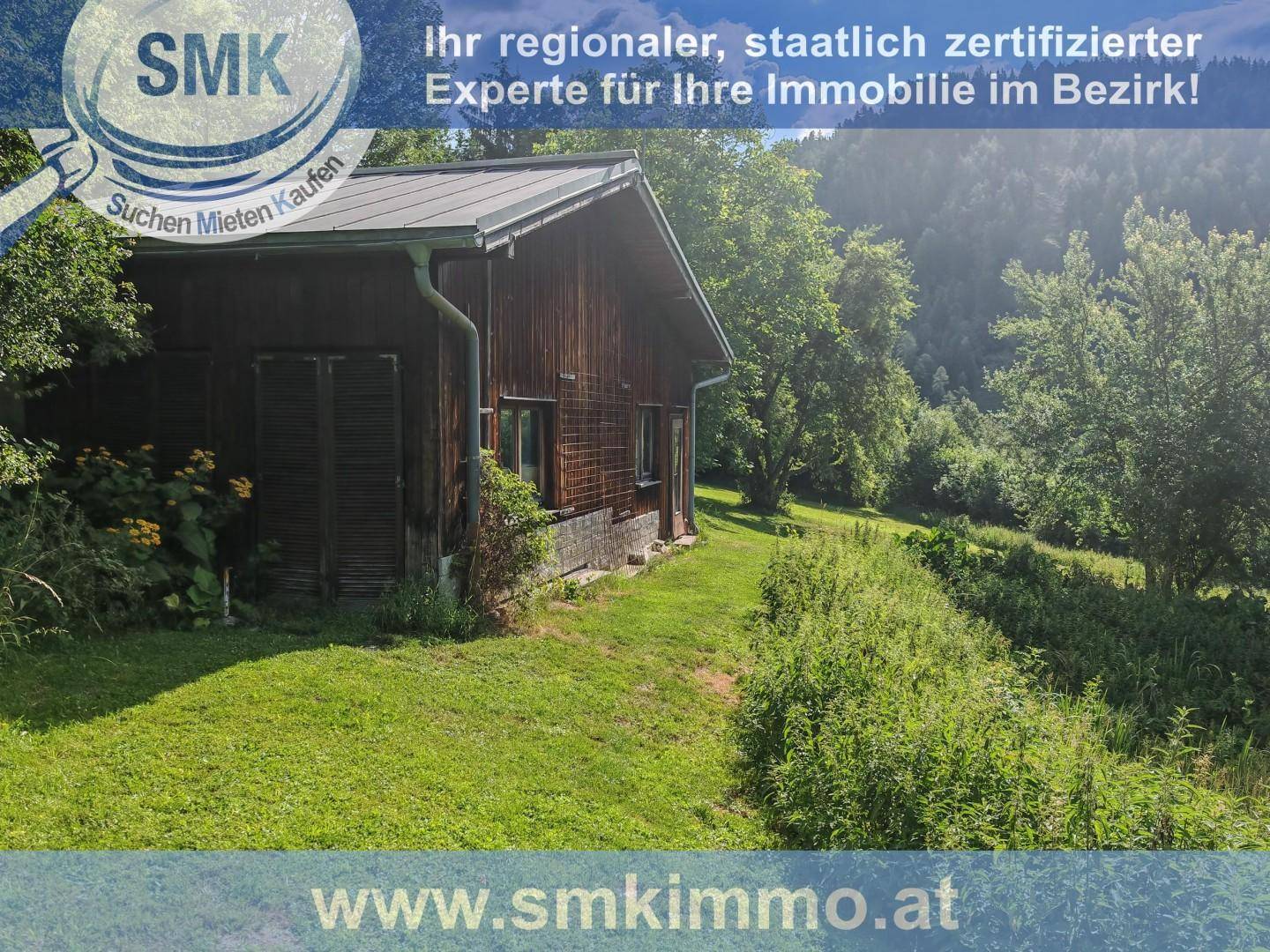 Rustikales Holzhaus im Grünen, umgeben von Wiesen und Bäumen, in idyllischer Landschaft.
