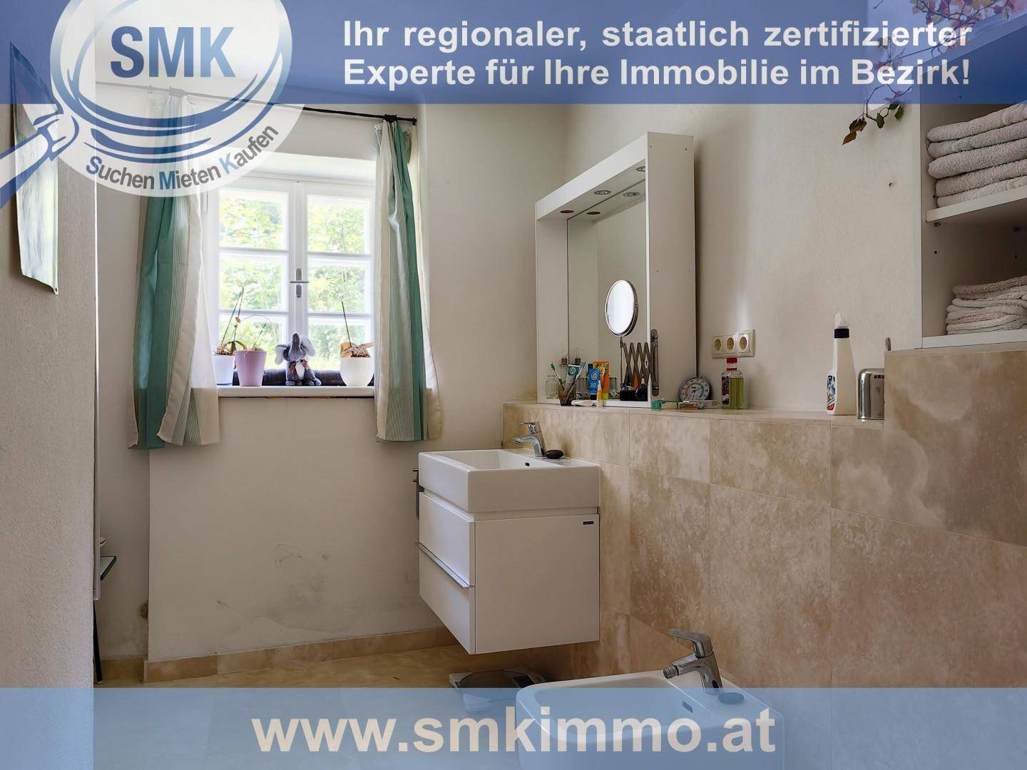 Helles Badezimmer mit modernem Waschtisch, Bidet und einem Fenster mit Blick ins Grüne.