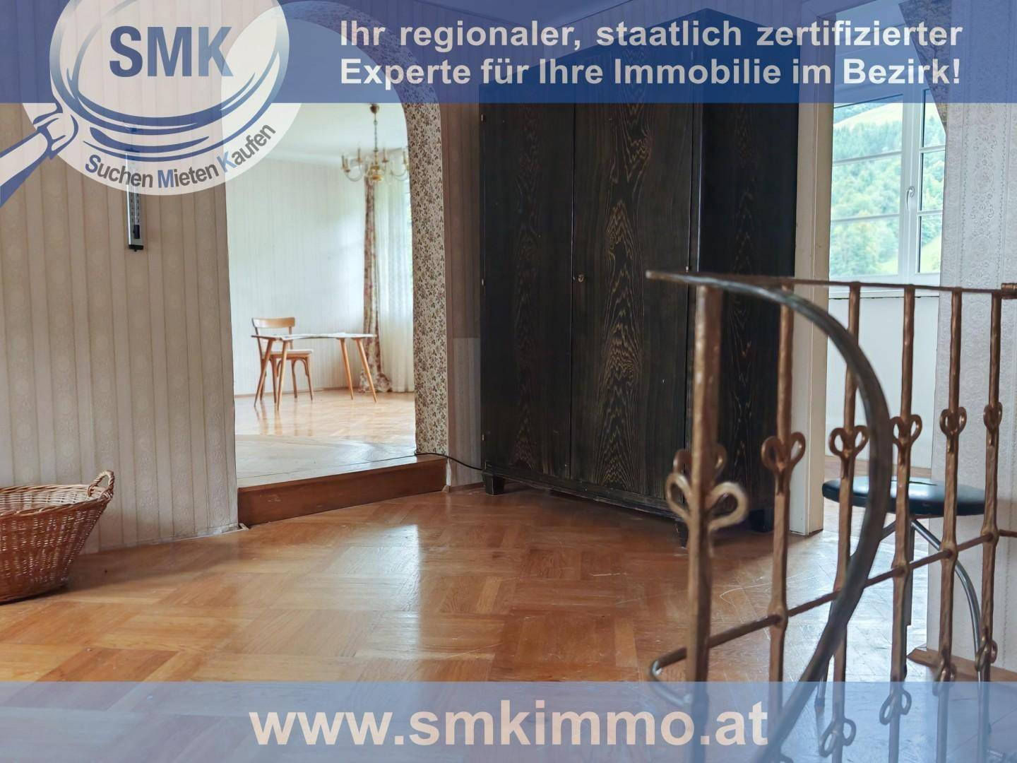 Heller Flur mit Parkettboden und einem großen Holzschrank, der zu einem Wohnbereich führt.