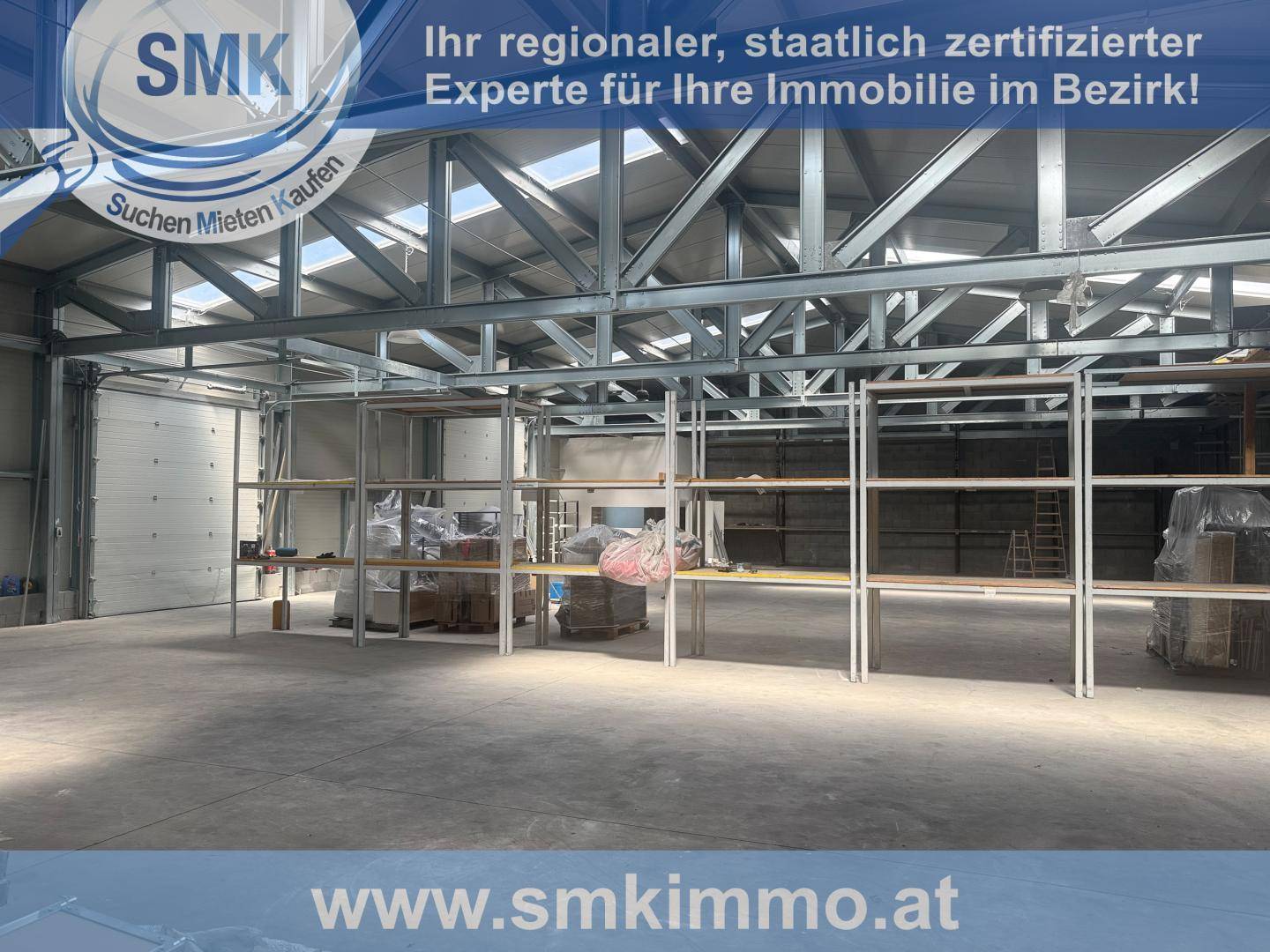 Innenansicht der Lagerhalle mit hohen Decken, sichtbaren Metallträgern und Regalen.