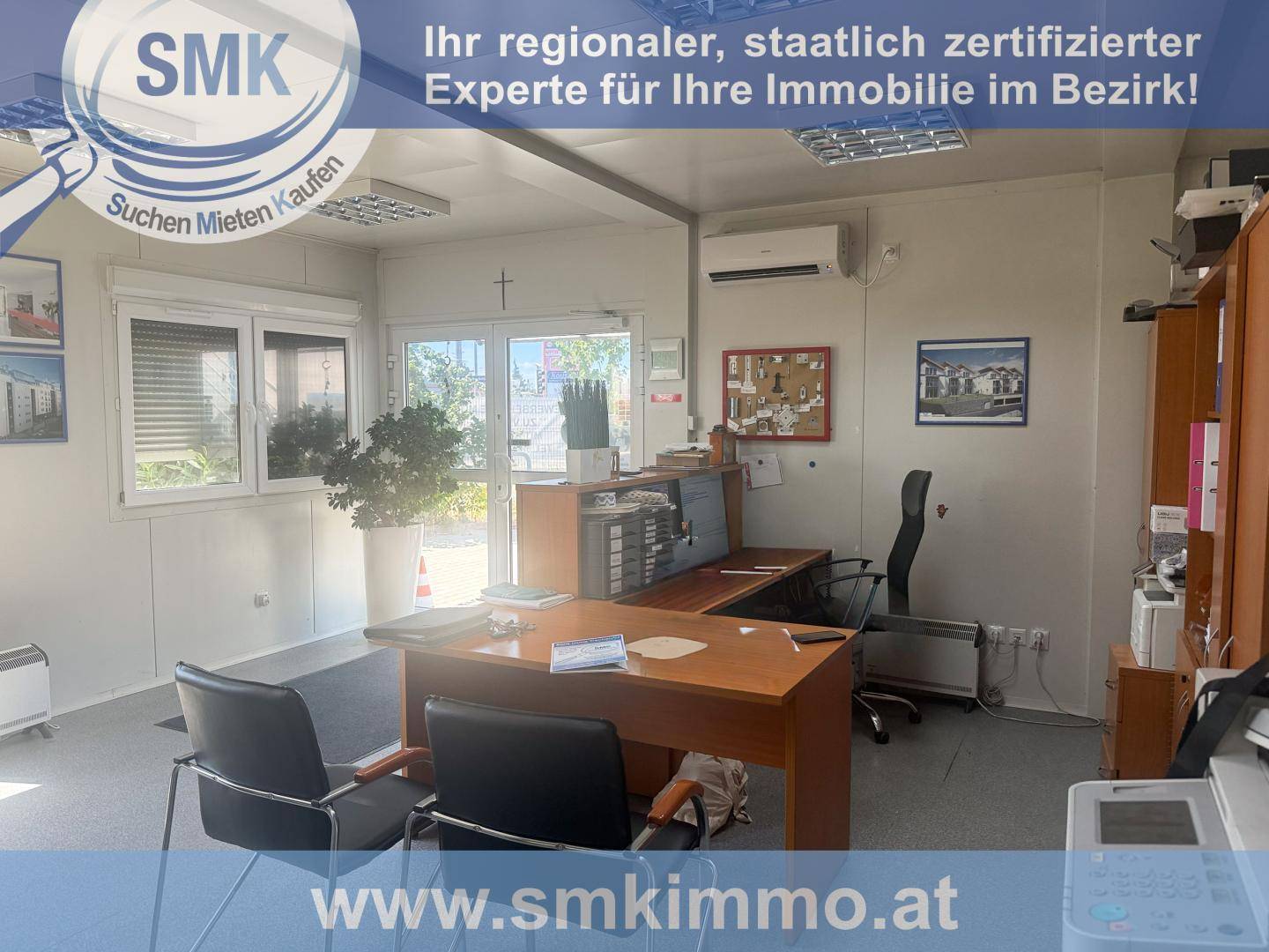 Großes Büro mit mehreren Arbeitsplätzen, Bürostühlen, Drucker und einer Klimaanlage an der Wand.