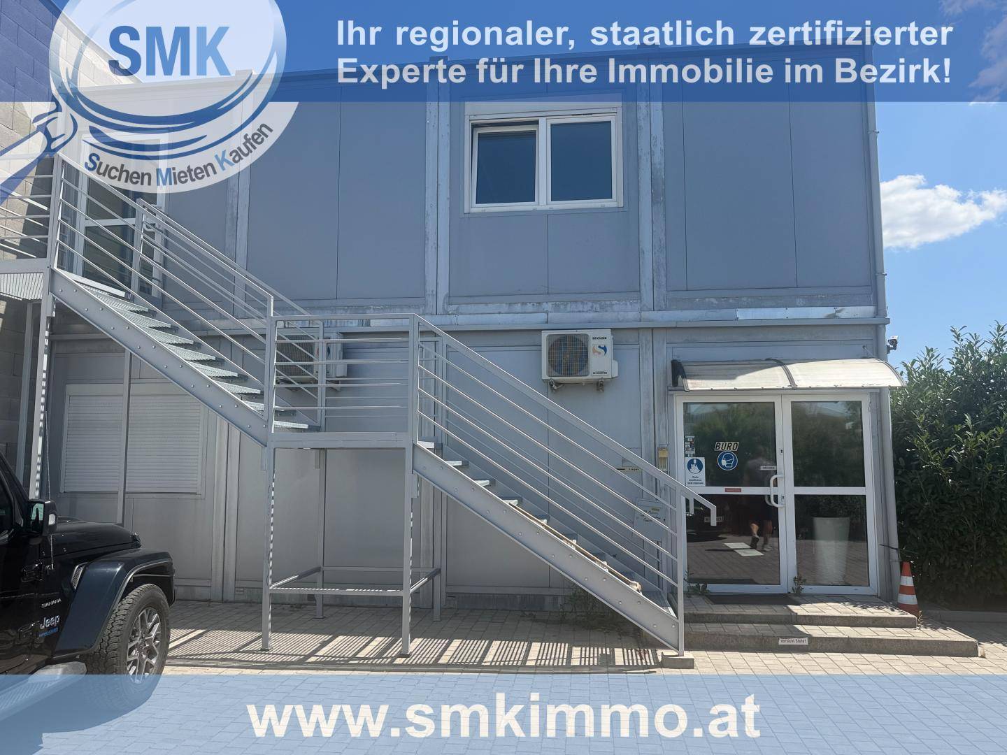 Außenansicht eines modularen Bürogebäudes mit einer externen Metalltreppe und Klimaanlage.