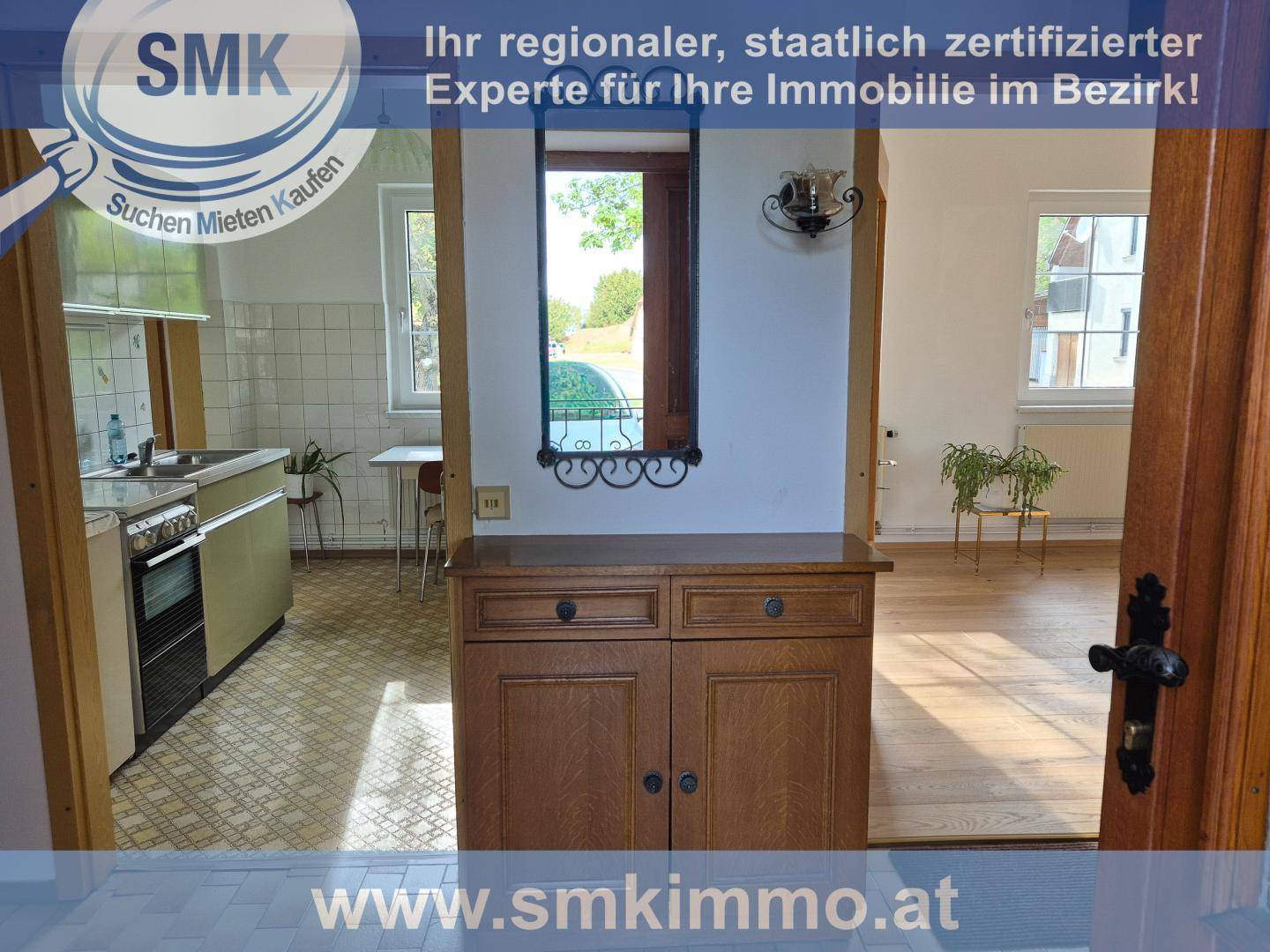 Flur mit Holzschrank und Durchgang zu Küche und weiteren Räumen.
