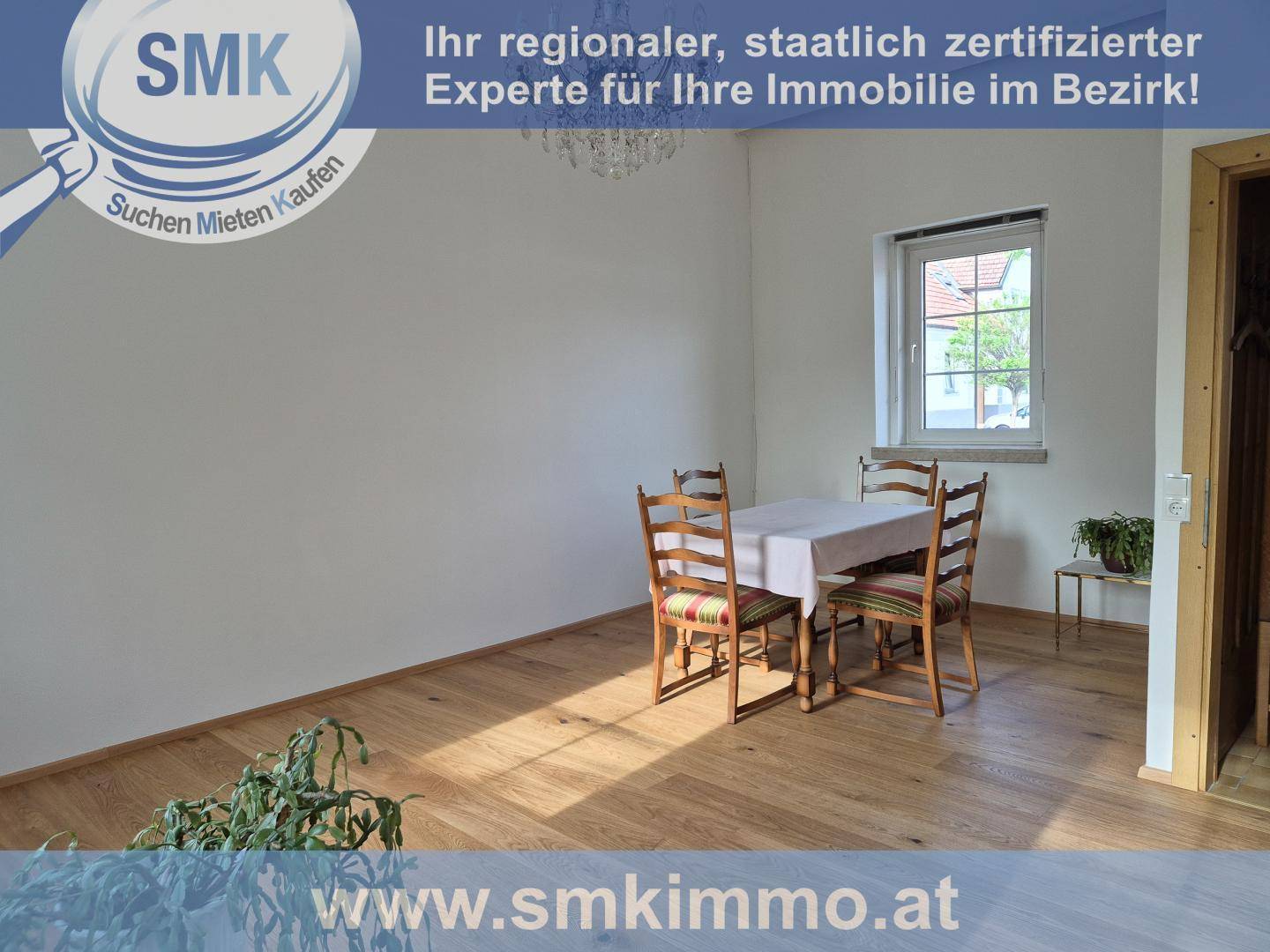 Heller Essbereich mit Holzboden, Esstisch und Blick ins Grüne durch das Fenster.