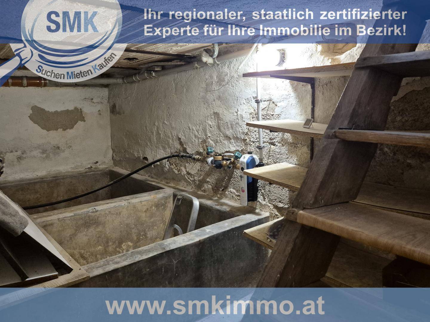Unfertiger Kellerraum mit Betonwannen, sichtbaren Rohren und einfachen Regalen.