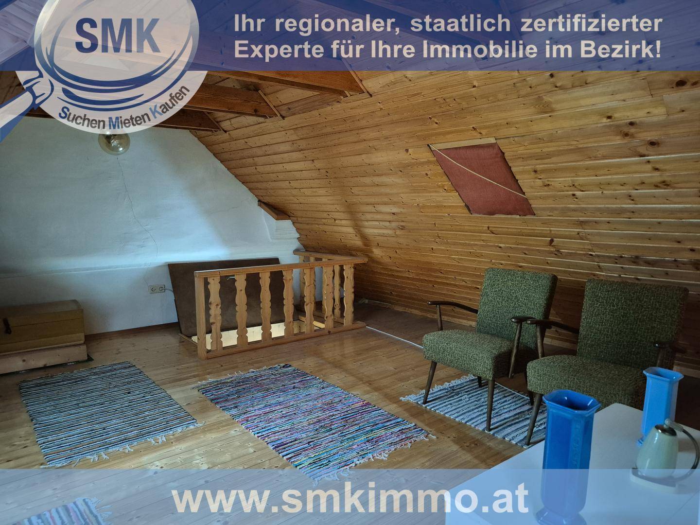 Gemütlicher Dachbodenbereich mit Holzverkleidung und zwei Sesseln zum Entspannen.
