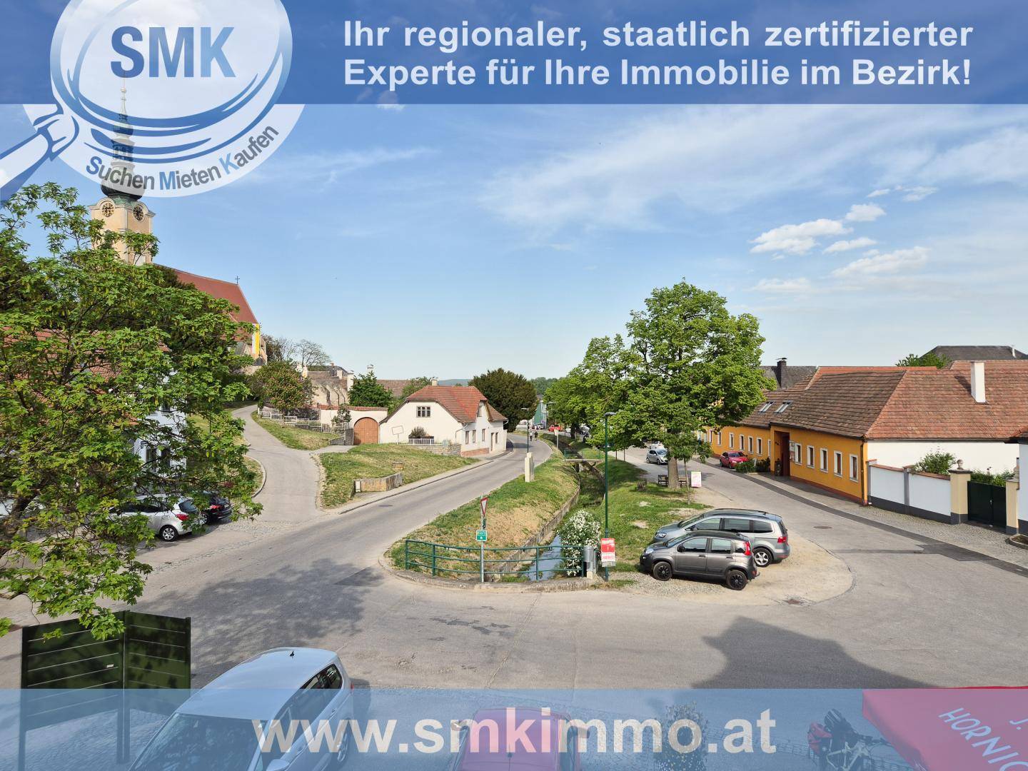Weitläufiger Blick auf die ländliche Umgebung mit Häusern und viel Grün.