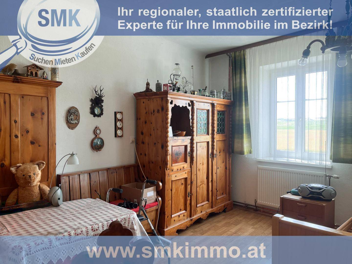 Gemütlicher Raum mit traditionellen Holzmöbeln, einem Fenster und einem Heizkörper.