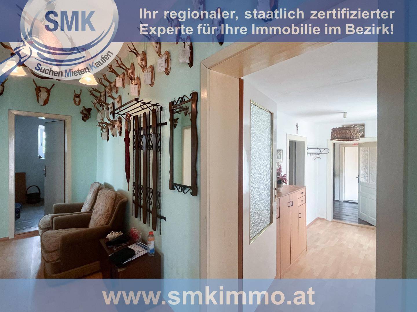 Traditioneller Flur mit Holzparkettboden und rustikaler Dekoration, inklusive Hirschgeweihen an der Wand.