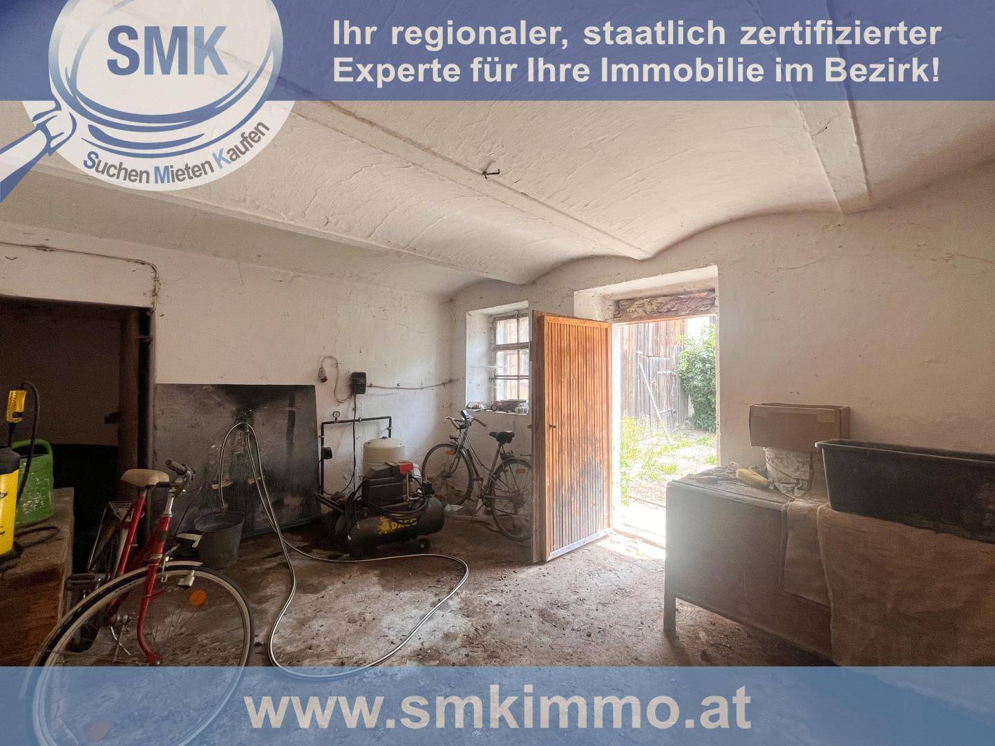 Rustikaler Raum mit gewölbter Decke, Fahrrädern und verschiedenen Geräten, möglicherweise eine Werkstatt.