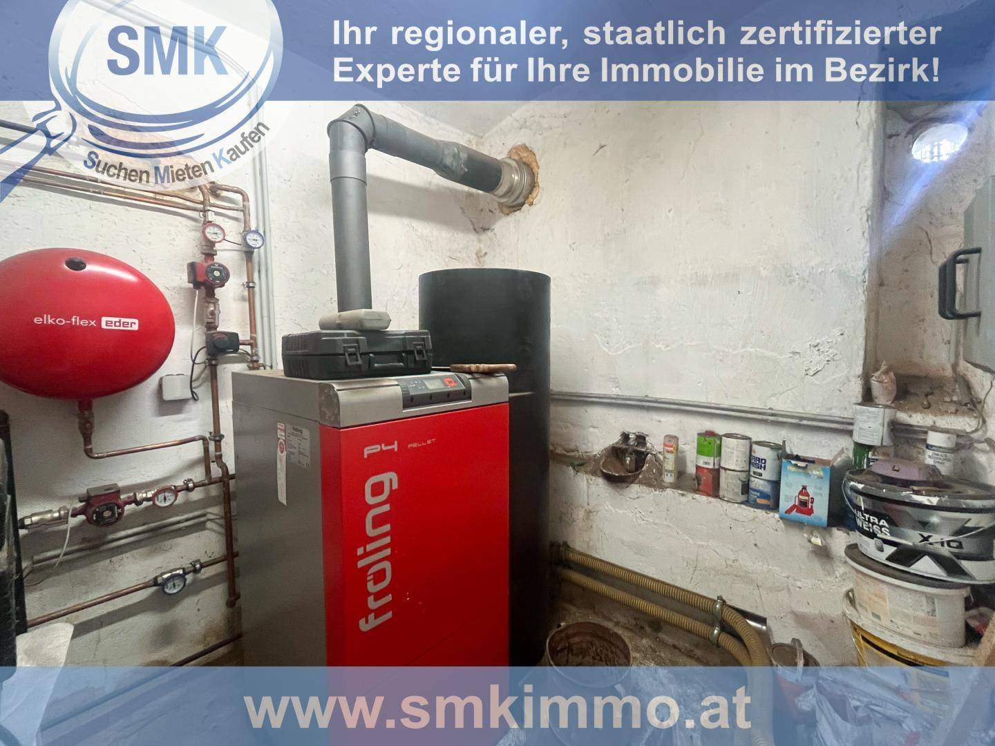 Heizraum mit einem modernen Froling Heizsystem und verschiedenen Rohren und Tanks.