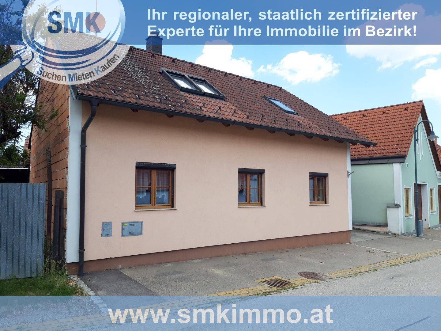 Seitenansicht des Hauses mit beiger Fassade, Fenstern und Blick auf die ruhige Straße.