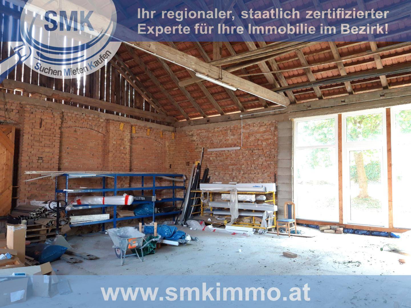 Großer Scheunenraum mit Ziegelwänden, Holzdachkonstruktion und Lagerregalen.