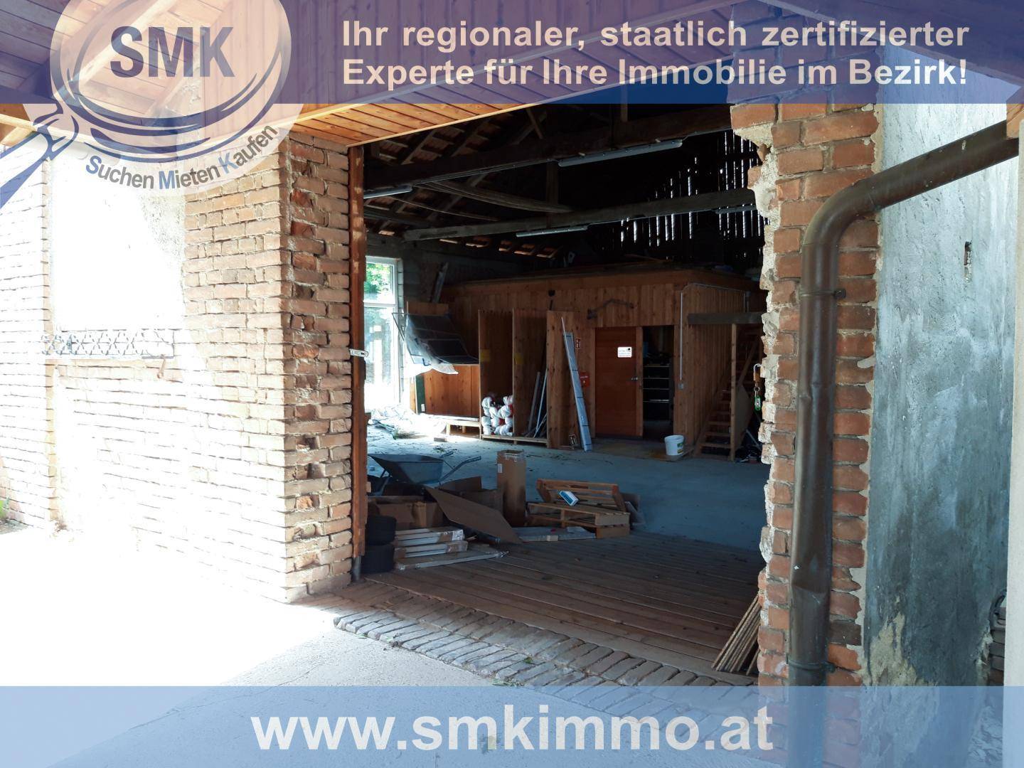 Innenansicht einer Scheune mit sichtbaren Ziegelwänden und Holzkonstruktionen.