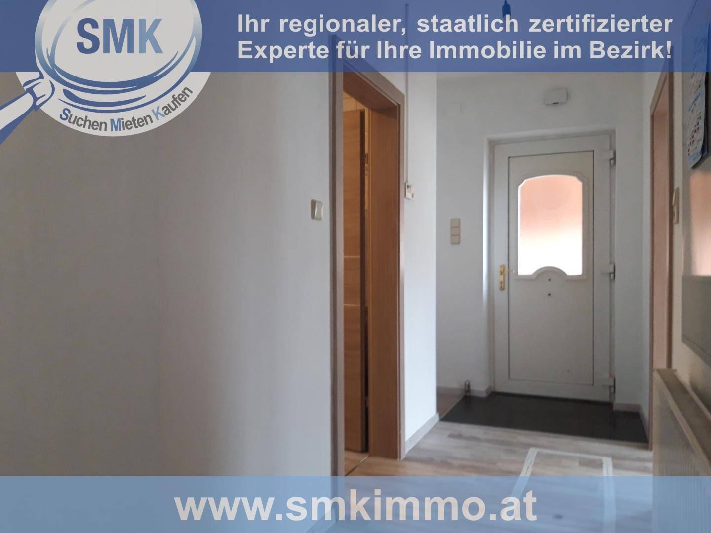 Eingangsbereich mit heller Haustür, Laminatboden und Zugang zu weiteren Räumen.